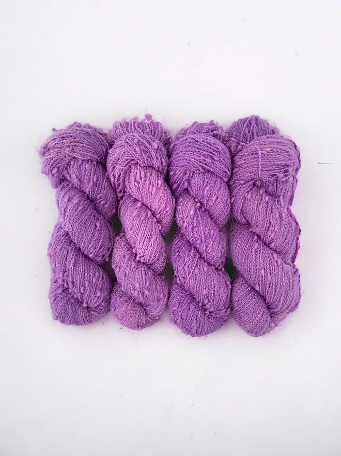 HYDRANGEA yarn offers a unique blend of merino and nylon for added durability. The textured slub design in pink/purple adds depth and dimension to any project. Each 100g skein is perfect for lightweight, yet sturdy, fingering weight projects.