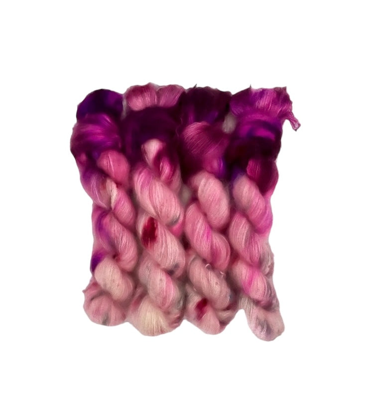 Experience the luxurious softness and lustrous sheen of our SHOW OFF - Kid Mohair And Silk Lace Weight Yarn. Made with 72% Kid Mohair and 28% Mulberry Silk, this hand dyed yarn features a beautiful blend of plum violet, pale pink, and grey. Elevate your knitting and crocheting projects with this elegant and high-quality skein.