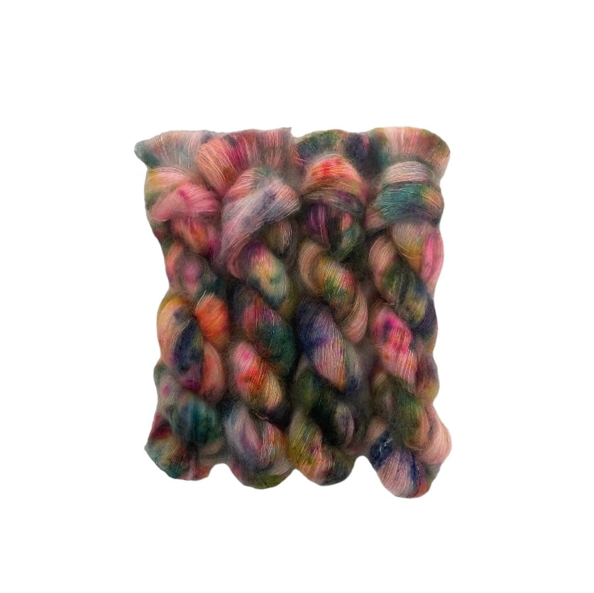 Made from luxurious kid mohair and silk, this lace weight yarn is hand dyed in a unique mix of green, pink, orange, blue, and gold. Add a one-of-a-kind touch to your projects and enjoy the softness and sheen of this exquisite yarn. Perfect for delicate lacework.