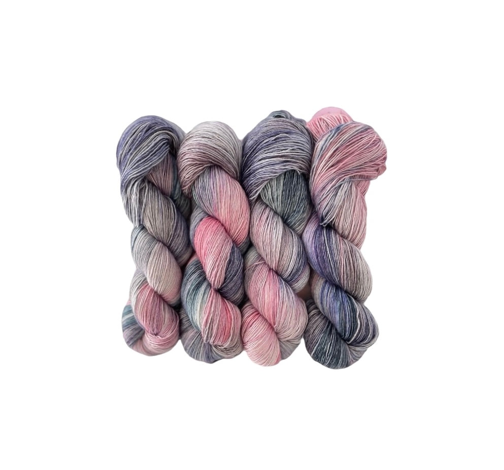 Experience the luxurious softness of hand-dyed single-ply yarn made from a luxurious blend of merino wool and silk. The delicate pink, grey, and teal blue color combination will add a touch of elegance to your projects. Perfect for knitting or crocheting a one-of-a-kind piece for your next first date.