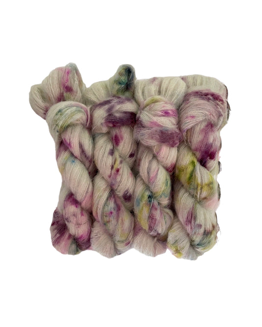 Experience the luxurious softness of our COTTAGE CHARM lace weight yarn, made with Suri Alpaca and Mulberry Silk. Hand-dyed in a beautiful sage green with pops of violet and green, creating a unique and elegant colorway. Enjoy the benefits of this premium blend for your next knitting or crochet project.