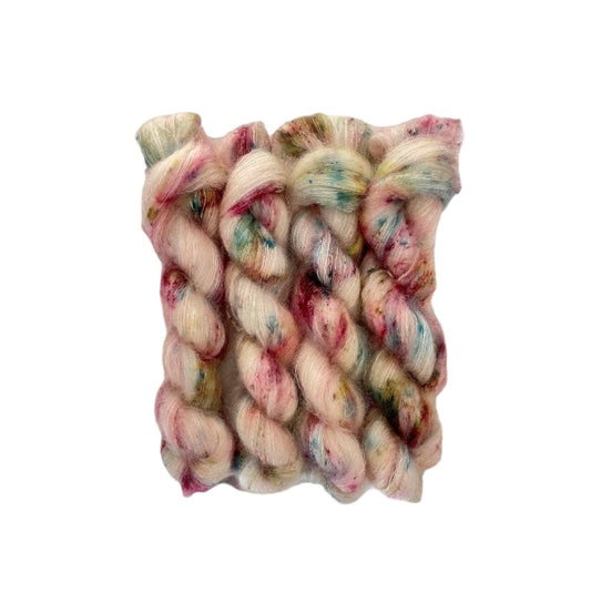 Expertly hand-dyed with a cream base and delicate dashes of green, blue, and berry colors, our COTTAGE GARDEN yarn is crafted from Kid Mohair and Silk for a luxurious lace weight feel. Enhance your projects with a touch of natural elegance.