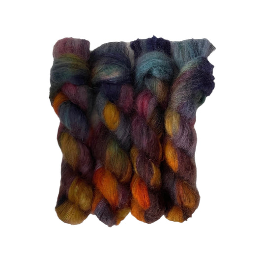 ENCHANTED hand-dyed yarn is a blend of kid mohair and silk, creating a soft and lightweight texture. The beautiful moody colors of purple, bronze, gold & blue  will add a unique touch to your knitting projects. Each 50g skein is carefully crafted for a truly one-of-a-kind piece.