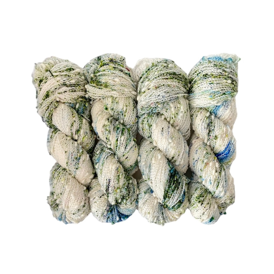 This yarn offers a unique blend of merino and nylon for added durability. The textured slub design adds depth and dimension to any project. Each 100g skein is perfect for lightweight, yet sturdy, fingering weight projects. A cream/white base speckled cream & blue,