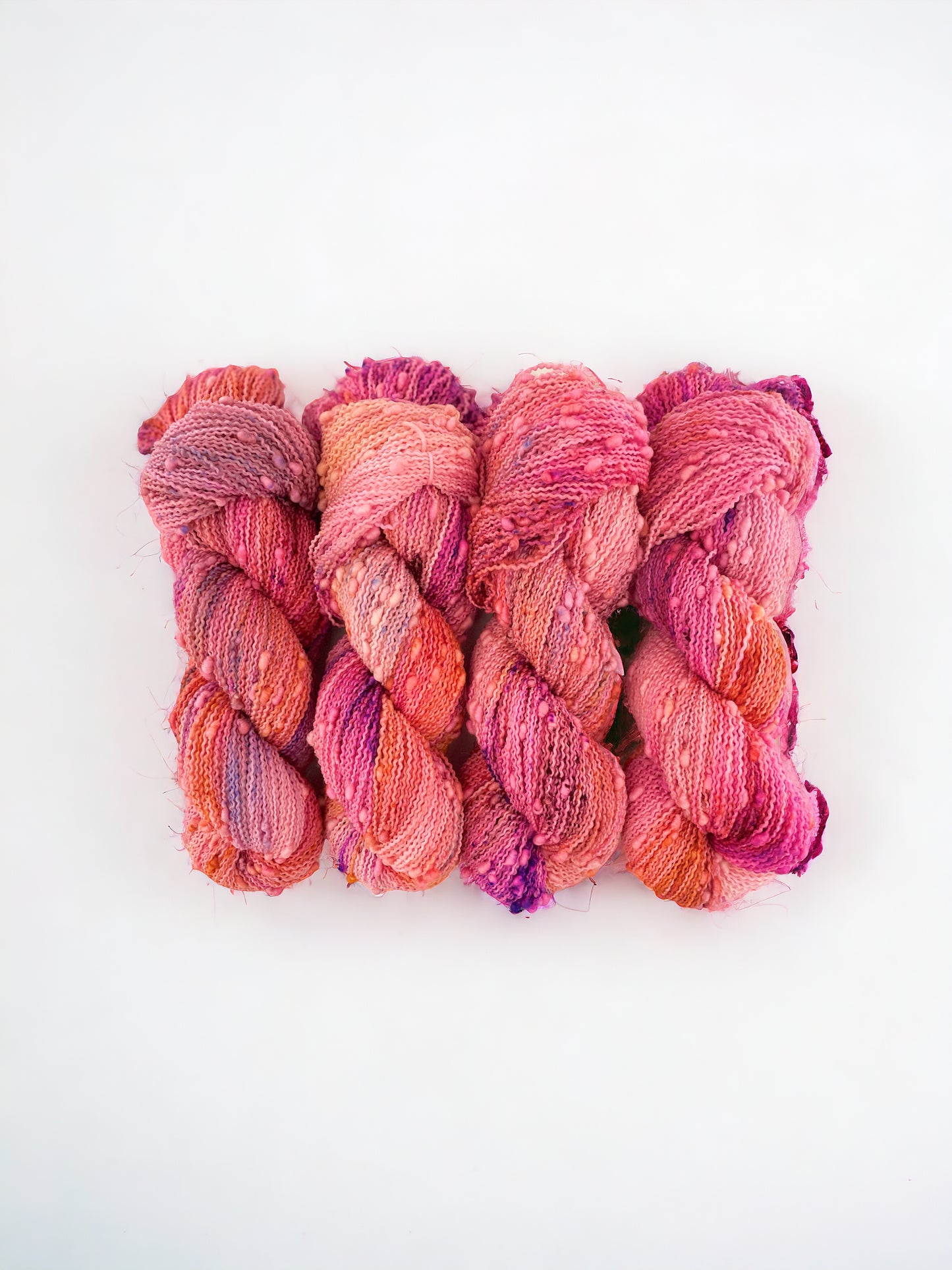 Bobble fingering/sock weight.  90% Super Wash Merino.  10% Nylon.Hand dyed in shades of coral and pink, this yarn brings a touch of warmth and vibrancy to any project. Perfect for sweaters and next to skin accessories.