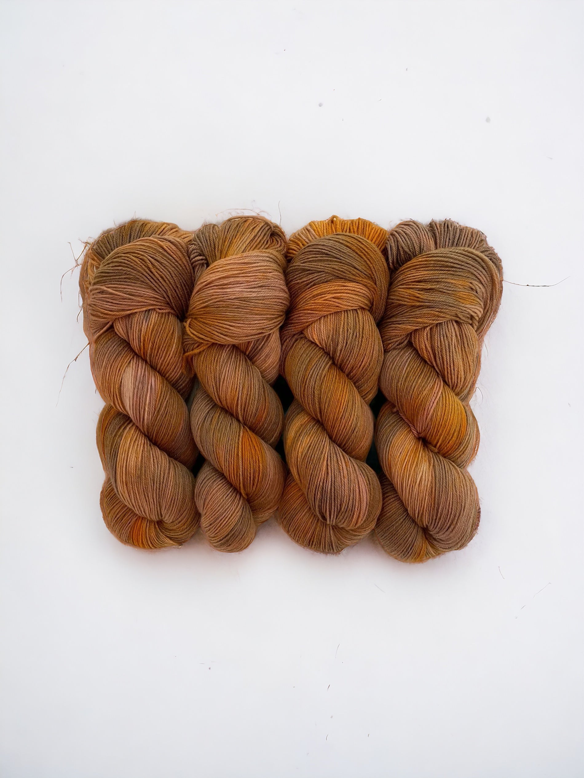 Introducing our hand-dyed Copper Pot yarn! Made from 100% sustainable Merino wool, this fingering/sock weight yarn boasts beautiful copper orange hues. Perfect for eco-conscious knitters looking for high-quality, unique yarn. Each 100g skein is carefully hand-dyed for a one-of-a-kind result.