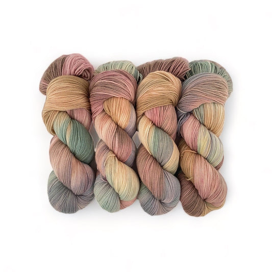 The DUSTY PATH Hand Dyed Yarn is made from 100% sustainable Merino wool and is available in a 100g skein. This fingering/sock weight yarn features a unique blend of beige, brown, green, and grey tones, making it a versatile and eco-friendly choice for all your knitting and crochet projects.