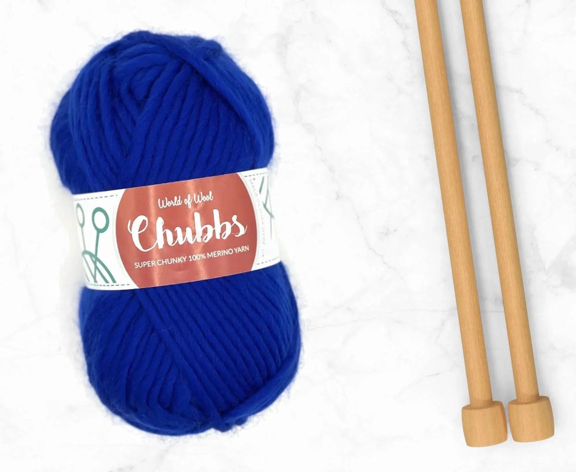 Blue yarn ball of super chunky 100% merino wool with World of Wool 'Chubbs' label and wooden knitting needles on a white background