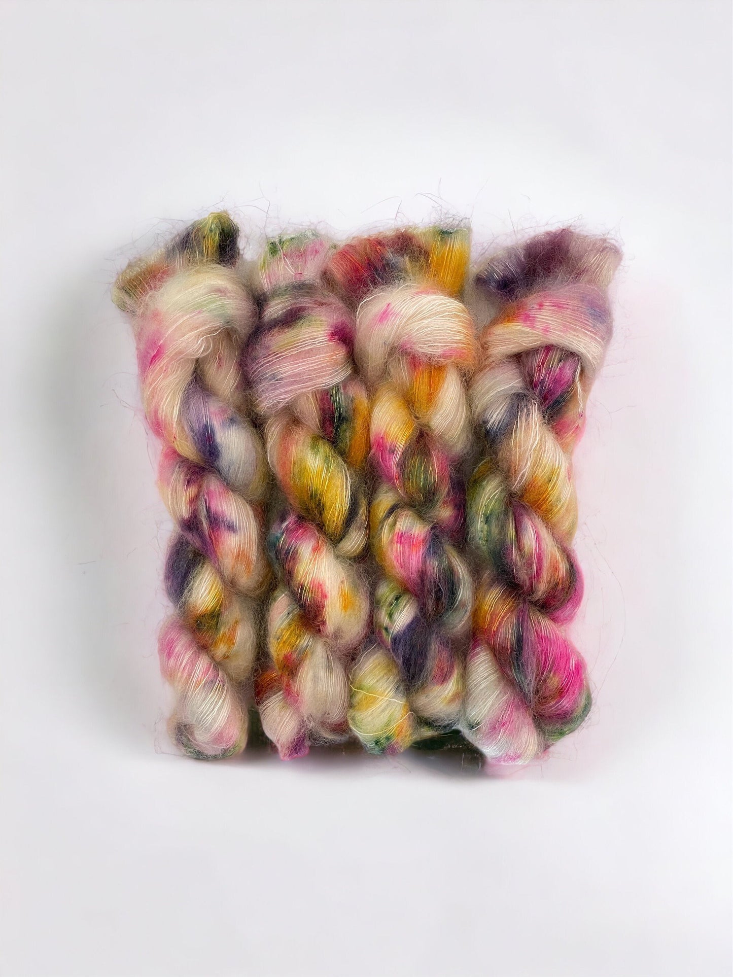 Made from luxurious kid mohair and silk, this lace weight yarn is hand dyed in a unique mix of cream, green, pink and yellow. Add a one-of-a-kind touch to your projects and enjoy the softness and sheen of this exquisite yarn. Perfect for delicate lacework.   